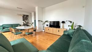 a living room with a green couch and a table at Colosseo Deluxe YH in Rome