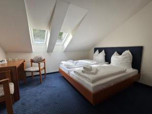 a bedroom with a bed and a desk and a chair at Barbarossa Hotel Kelbra in Kelbra