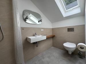 a bathroom with a sink and a toilet and a mirror at Barbarossa Hotel Kelbra in Kelbra +29 photos