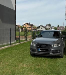 a car parked on the grass in a yard at Apartman HODŽIĆ in Sarajevo +2 photos