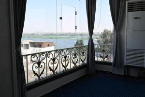 a room with a balcony with a view of a river at فندق شهرزاد - Shahrazad Hotel in Banī ‘Aţīyah +30 photos