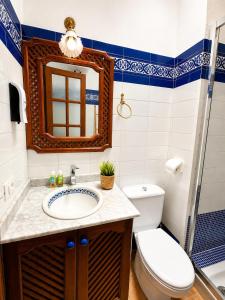 a bathroom with a sink and a toilet and a mirror at Deluxe Mogán Beach Apt 2 in Puerto de Mogán +15 photos