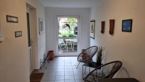 a hallway with two chairs and a door with a table at Ulli's Oase in Uettingen