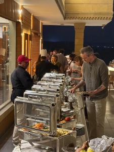 a group of people standing around a buffet of food at Pyramids sunrise inn in Cairo +282 photos