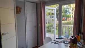 a kitchen with a sliding glass door leading to a porch at Mobil Home AGDE Hérault in Agde +13 photos