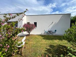 a white building with two chairs and a table at Studio rez-de-jardin la Baule proche centre Pornichet in La Baule