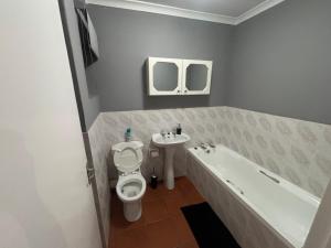 a bathroom with a tub and a toilet and a sink at Paradise Cove Marina in Jeffreys Bay +26 photos