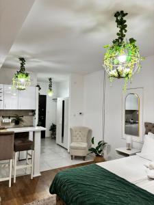 a bedroom with a bed and a desk and chandeliers at Apartman Vanila Lux Kragujevac in Kragujevac