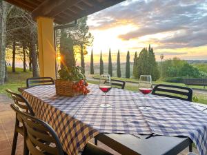 a table with wine glasses and a basket of fruit at Villa Panconesi in Montespertoli