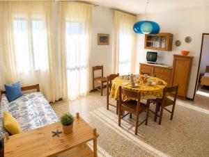 a living room with a dining room table and a kitchen at Casa Francesca - Agenzia Cocal in Caorle +10 photos