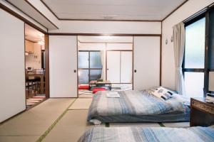 a bedroom with two beds and a window at Green Hights Residence-107 in Naha