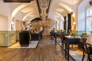 a restaurant with tables and chairs and a man standing in the background at Boutique Hotel Parklane - Newly Renovated in Vienna +39 photos
