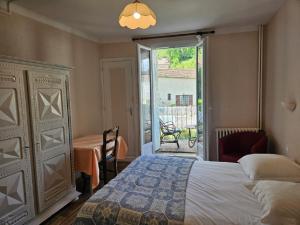 a bedroom with a bed and a door to a patio at Hostellerie de La Poste in Oust +91 photos