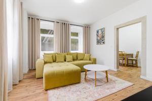 a living room with a yellow couch and a table at Panorama Apartments an der Seilbahn unterhalb der Albrechtsburg - Parkplatz und Wi-Fi - FREE in Meißen