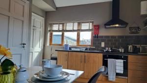a kitchen with a table with cups and plates on it at 9 Suíomh Alainn in Kilgarvan