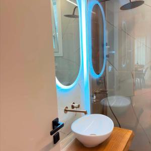 a bathroom with a white sink and a mirror at Sea & Sun Luxury Apartment in Alexandroupoli +12 photos