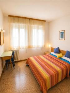 a bedroom with a bed and a desk and a window at Casa Francesca - Agenzia Cocal in Caorle