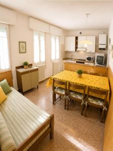 a living room with a table and a kitchen at Casa Francesca - Agenzia Cocal in Caorle