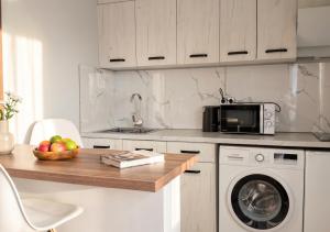 a kitchen with a table with a bowl of fruit and a microwave at 40 m2 Confort apartament in Bălţi