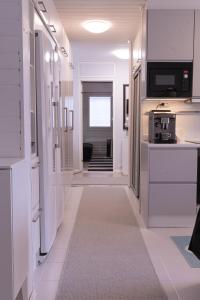 a hallway with white walls and a hallway with a kitchen at Villa White Star in Rovaniemi
