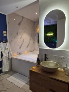 a bathroom with a sink and a tub and a mirror at Ciao Bella Wellness Suite - Luxury Jacuzzi, Massage Table & AC in Central Nice in Nice