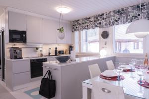 a kitchen with white cabinets and a table with chairs at Villa White Star in Rovaniemi +22 photos