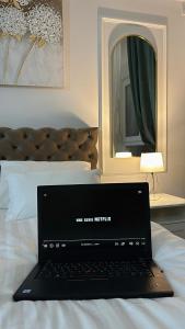 a laptop computer sitting on top of a bed at Apartman Vanila Lux Kragujevac in Kragujevac