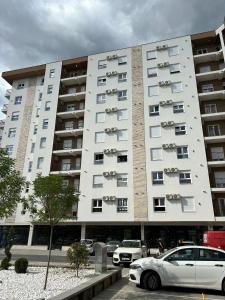 a large white building with cars parked in front of it at Apartman Vanila Lux Kragujevac in Kragujevac