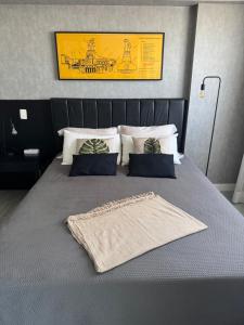 a bed with two pillows and a blanket on it at Apartamento moderno e aconchegante com vista para a Esplanada in Brasília +4 photos