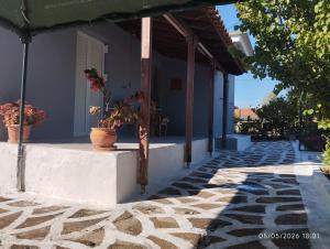 a porch of a house with potted plants on it at Victoria's Summer House in Amalias