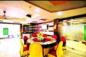 a dining room with a table and red chairs at N S International in Kolkata