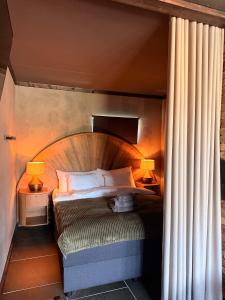 a bed with a wooden headboard in a room at Parkside studio in Hjo