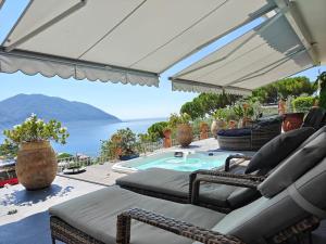 a patio with chairs and a swimming pool at Villa Carpediem - Luxury Private Stay Front Sea Portofino Coast in Recco