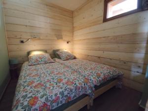 a bedroom with a bed in a wooden wall at Marla 52 in Le Dévoluy