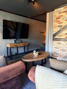 a living room with a table and a television at Parkside studio in Hjo