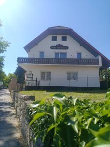 a white building with a fence in front of it at Anna Vendégház in Hévíz