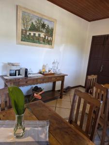 a dining room with a table with a vase at Casa Trindade in Tiradentes +10 photos