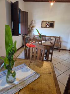 a dining room with a table and a vase on a table at Casa Trindade in Tiradentes