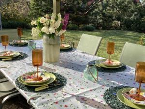 a table with plates of food and a vase of flowers at Apartments for Rent near Budapest in Etyek
