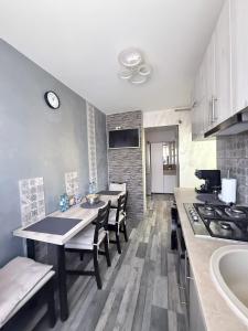 a kitchen with a table and chairs and a stove at Cozy Urban Apartment in Câmpulung