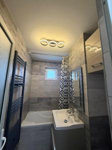 a bathroom with a tub and a sink and a bath tub at Cozy Urban Apartment in Câmpulung +9 photos