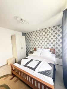 a bedroom with a large bed with white sheets at Cozy Urban Apartment in Câmpulung