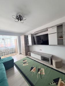 a living room with a couch and a tv at Cozy Urban Apartment in Câmpulung
