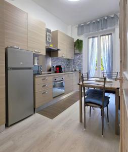 a kitchen with a table and a stainless steel refrigerator at Giuly Sole e Sale in Le Grazie