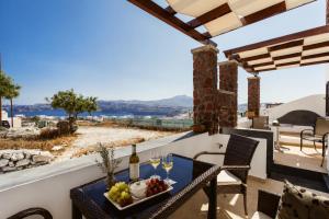 a table with wine glasses and a tray of food at Aelia Suites Akrotiri, Santorini in Akrotiri