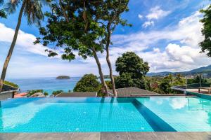 a swimming pool with a view of the ocean at Anthiya Seaview Villa Hotel Phuket in Kata Beach