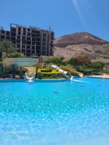 a pool with a water slide in a resort at Alraha Resort in Aqaba