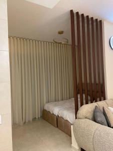 a crib in a room with a curtain and a couch at Alraha Resort in Aqaba