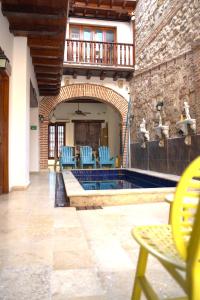 a patio with blue chairs and a swimming pool at Akel House Hotel - Getsemaní - Cartagena in Cartagena de Indias