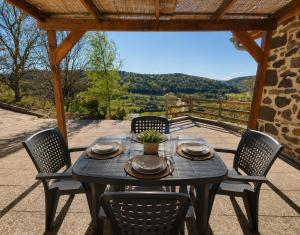 a table and chairs on a patio with a view at La maison vigneronne in Polignac